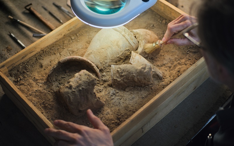 Archéologue nettoyant une vieille poterie trouvée sur des fouilles archéologiques