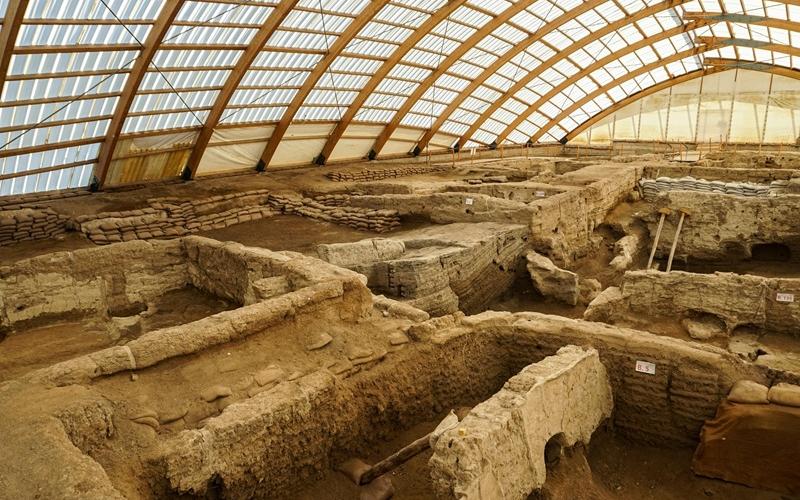 Fouilles archéologiques protégées par une structure avec une charpente en bois